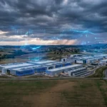 SoftBank data centers IA en France : vue aérienne de bâtiments modernes avec éclairage bleu technologique